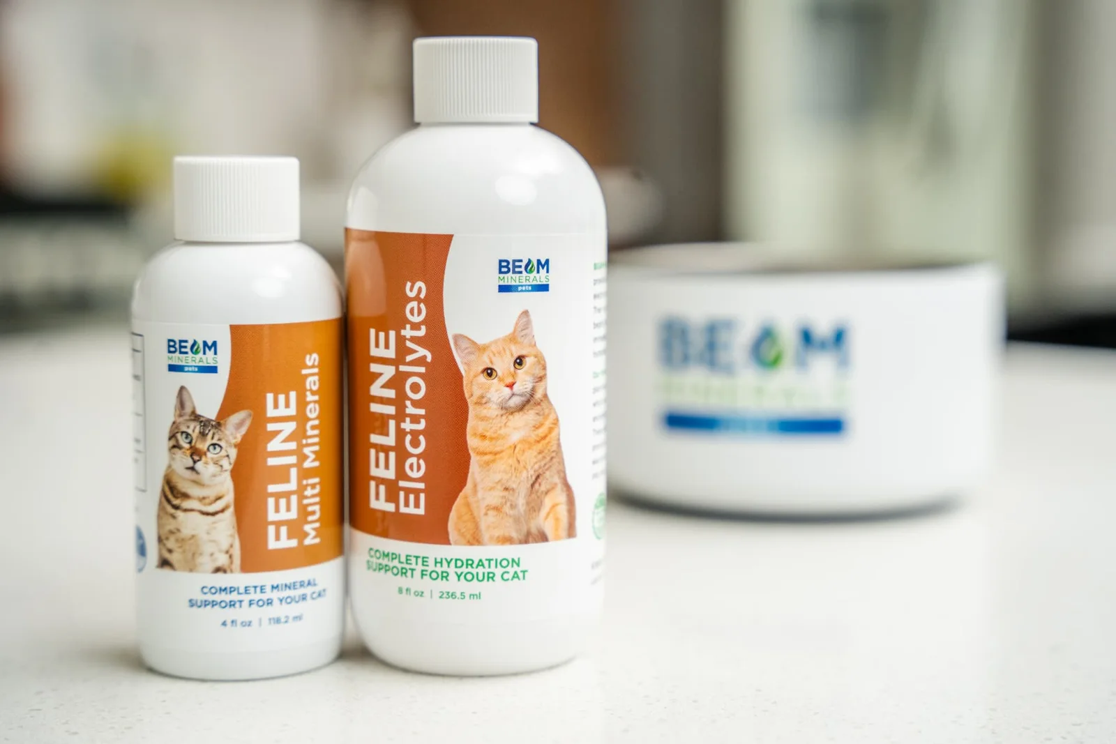 BEAM Minerals Pets Feline Multi-Minerals and Feline Electrolytes bottles beside a pet bowl